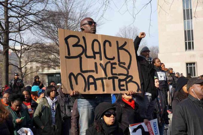 Človek, ki protestira nad smrtjo Michaela Browna, Erica Garnerja in Tamirja Ricea, v Washingtonu DC prikazuje Črno življenje.
