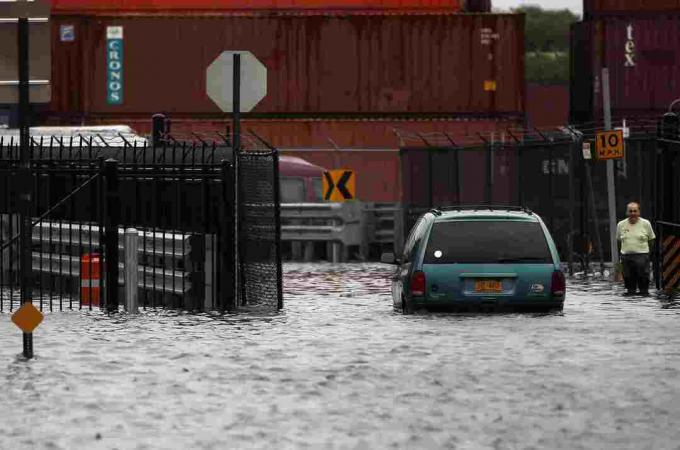 Oseba se sprehodi po poplavljeni ulici po orkanu Irene 28. avgusta 2011 v soseski Red Hook v okrožju Brooklyn v New Yorku.