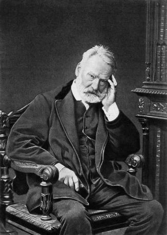 Victor Hugo sedi na stolu