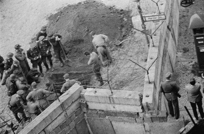 Skupina vzhodnonemških vojakov preiskuje predor, izkopan pod berlinskim zidom.