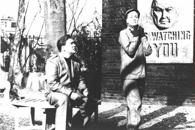 Igralca Edmond O'Brien in Jan Sterling s plakatom Big Brotherja za seboj v kadru iz filmske različice romana Georgea Orwella '1984.'
