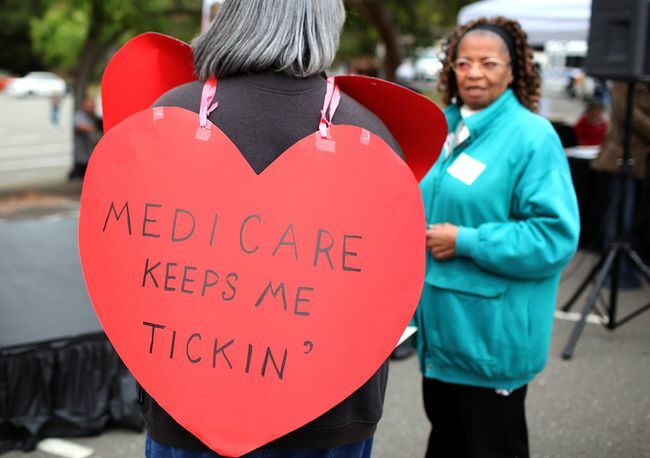 Ženska z napisom v obliki srca z napisom »Medicare Keeps Me Ticking«