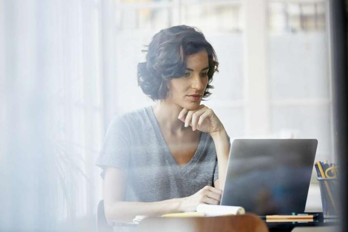 Mujer preveri información en computadora portátil.