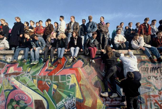 Ljudje se 10. novembra 1989 v praznovanju povzpnejo na berlinskem zidu.