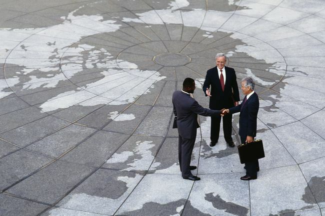  Gospodarski regionalizem: Podjetniki se rokujejo na zemljevidu sveta.