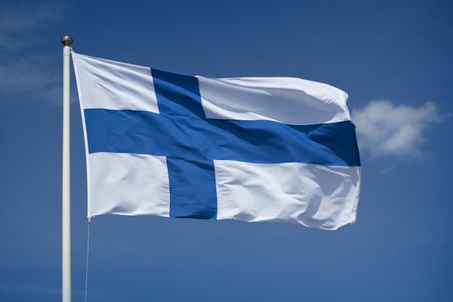 Izobešena finska zastava z modrim nebom v ozadju