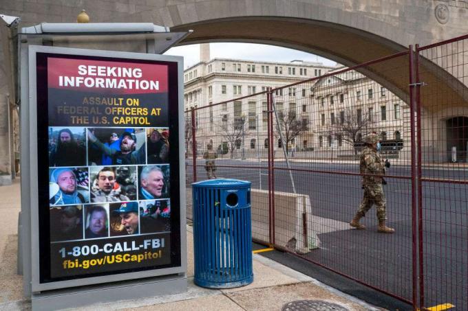 Nacionalni gardist gre mimo plakata, ki išče informacije o napadu na ameriški Kapitol 19. januarja 2021.