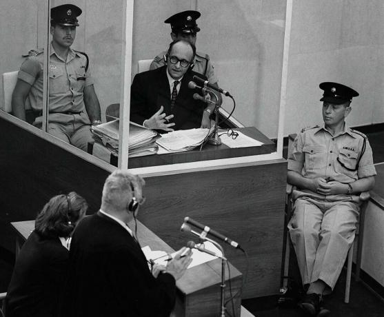 Nacistični vojni zločinec Adolph Eichmann stoji v zaščitni stekleni kabini, ki jo je med sojenjem 22. junija 1961 v Jeruzalemu postavila izraelska policija.